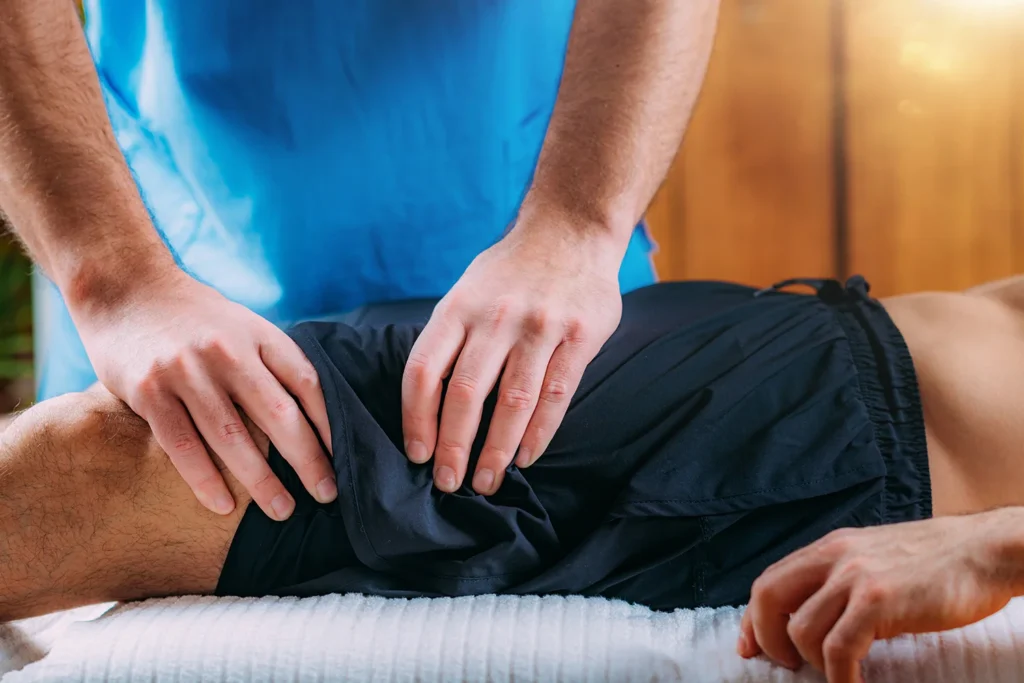 physical therapist working on patient s thigh